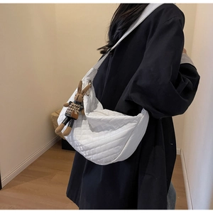 Détail du sac croissant matelassé blanc avec motif losange et pendentif lapin mignon