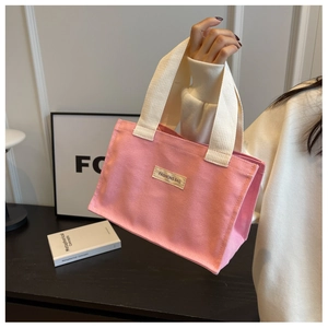 Détail du sac cabas en toile rose avec poignées tissées et étiquette FASHIONS BAG
