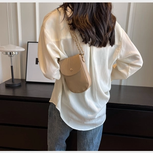 Detailansicht der hellbraunen Handy-Umhängetasche aus Leder mit Kette und Goldknopf