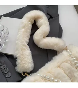Detailed shot of plush off-white faux fur shoulder bag with decorative pearl chain