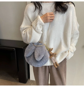 Detail of grey plush rabbit bag with gold chain strap and cute doll pendant