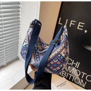 Detail view of the knit geometric pattern and wide strap on this ethnic style crossbody bag