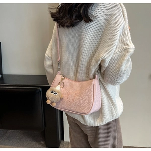 Détail du sac rose à nœud avec broderie papillon et breloque en peluche mignonne