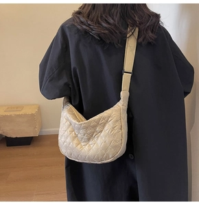 Quilted crossbody bag shown on model with adjustable strap and diamond lattice design