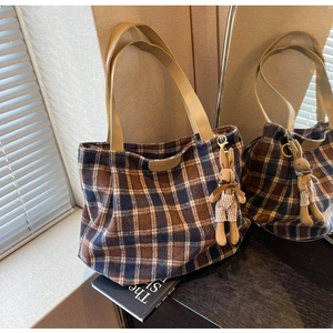 Detail of wool plaid tote bag with cute bunny pendant and fashion patch detail