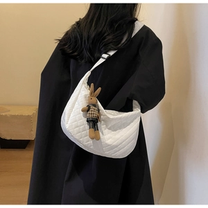 Détail du sac croissant matelassé blanc avec un pendentif lapin mignon porté au dos