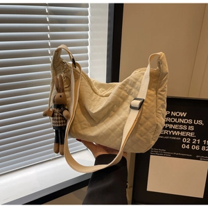 Détail du sac croissant matelassé blanc cassé avec bandoulière réglable et breloque lapin