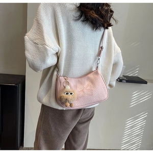 Détails du sac bandoulière rose avec broderie papillon et breloque en peluche
