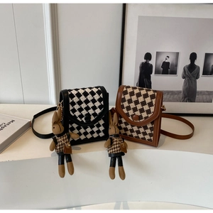 Detail of checkered tweed mini crossbody bags with cute plush bunny charms in a set