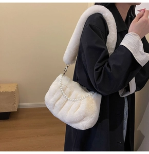 Detail of white plush shoulder bag featuring elegant pearl strap and soft fuzzy texture