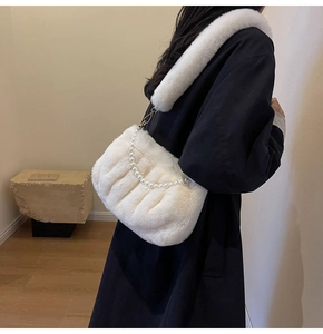 Detail of white faux fur shoulder bag with elegant pearl chain and plush strap