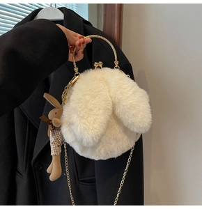Detail of white plush bunny bag with ornate gold handle and brown rabbit charm