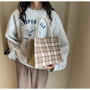 Détail du cabas à carreaux avec poignée en corde blanche et textile à carreaux marron
