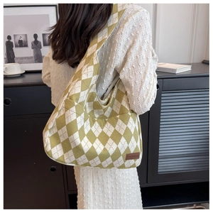 Detailed view of yellow and white argyle canvas tote bag with brown fashion patch