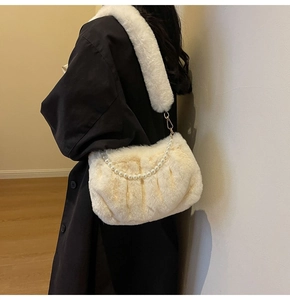 Detail of plush cream shoulder bag with large pearl chain decoration and fuzzy strap
