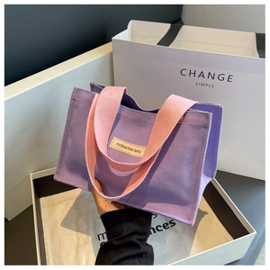 Détail du sac cabas en toile violette avec anses roses et étiquette tissée FASHIONS BAG