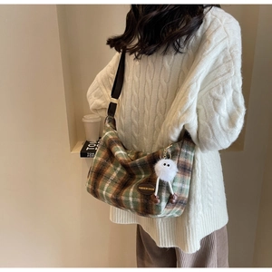 Détail du sac à main vintage en laine à carreaux avec bandoulière et charm en peluche