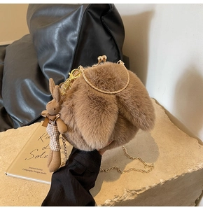 Detail of plush bunny ear crossbody bag featuring golden chain and cute knit rabbit charm
