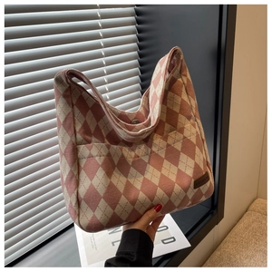 Detail of pink diamond pattern canvas tote with fashion leather label and snap closure