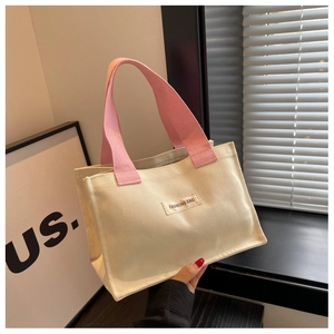 Vue détaillée du sac en toile avec poignées roses et étiquette FASHIONS BAG