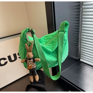 Détail du sac dumpling en nylon matelassé vert vif avec un charmant pendentif lapin