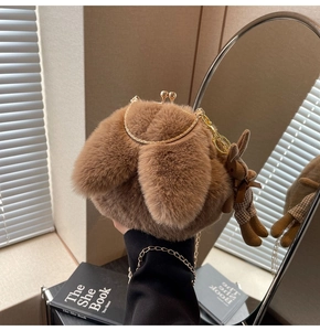 Close-up of fluffy brown rabbit-shaped plush bag with golden clasp and chain strap