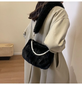 Detail of black faux fur cloud bag with large pearl chain and soft plush shoulder strap