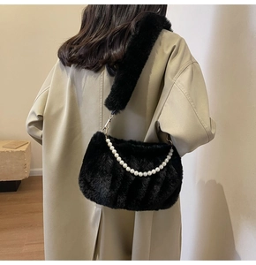 Detail of black faux fur shoulder bag with large pearl chain and soft plush texture