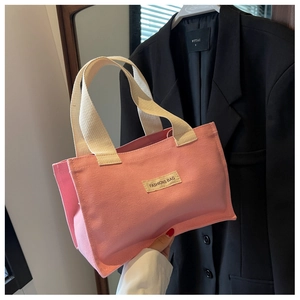 Détail du sac cabas en toile rose avec une étiquette en tissu Fashions Bag cousue