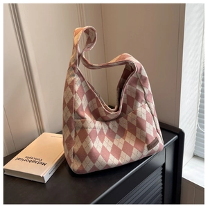 Detail of pink argyle knit canvas hobo bag featuring a leather fashion tag on side