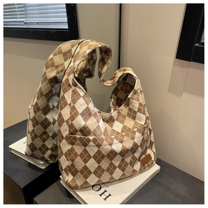 Detail of checkered canvas tote bag with side pocket and brown fashion leather patch