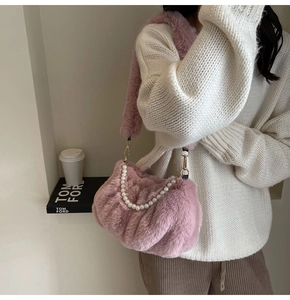 Close-up of pink plush cloud bag with pearl chain detail and soft fuzzy texture