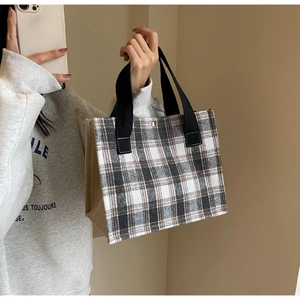 Détail du sac cabas en toile à damier avec sangle noire et couture en lin rustique