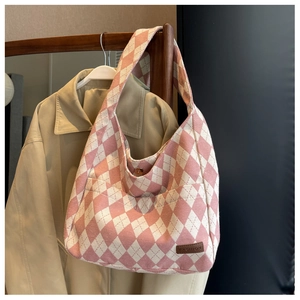 Detail of pink argyle canvas tote bag featuring magnetic buckle and FASHION leather label