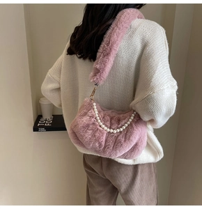 Detailed close-up of pink faux fur pleated shoulder bag with elegant pearl chain accessory