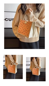 Detail view of corduroy tote bag with orange cherry pattern and wooden button closure