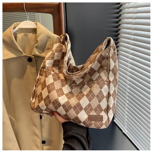 Detail of vintage plaid canvas tote bag with fashion leather patch and durable texture