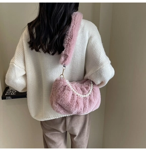 Detailed close-up of pink faux fur shoulder bag with elegant pearl chain and soft texture