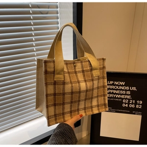 Détail du sac à déjeuner à carreaux avec sangles larges et fermoir à bouton-pression