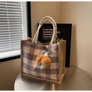 Detailed view of purple waffle weave tote bag featuring cute cherry plush pendants