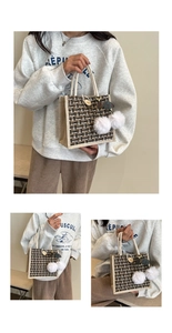 Detail of tweed tote bag with cotton rope handles and plush white pom-pom charms