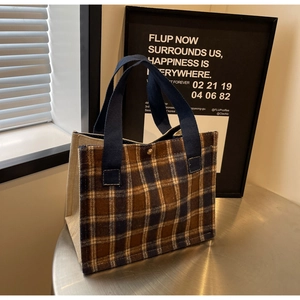 Détail du sac cabas à carreaux avec poignées en ruban bleu et fermoir à bouton doré