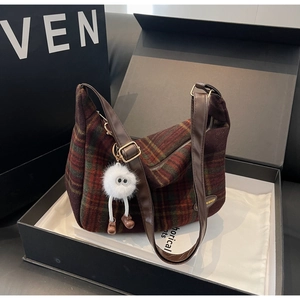 Détail du sac bandoulière vintage en laine à carreaux avec charm monstre en peluche
