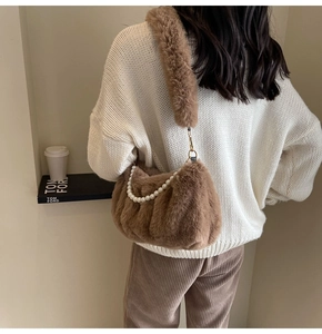 Detail of plush brown shoulder bag with decorative white pearls and fuzzy wide strap
