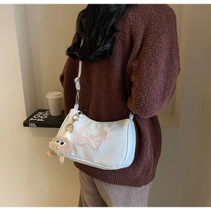 Vue détaillée du sac lune en cuir plissé blanc avec broderie papillon et breloque en peluche
