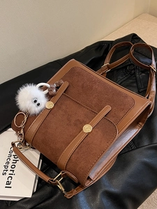 Vintage brown leather backpack with gold hardware and white plush charm detail