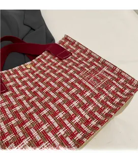 Close-up of red and white tweed weave texture with gold snap button on tote bag