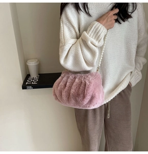 Detailed view of plush pink cloud bag with faux pearl strap shown in lifestyle setting