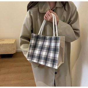 Détail du sac cabas à carreaux avec poignées en corde et bouton pression métallique