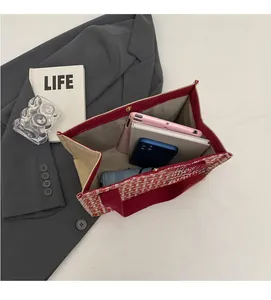 Top view of red and white woven tote bag showing spacious interior with tablet and phone